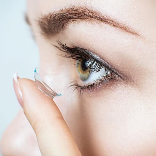 Woman putting in contact lenses