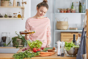 Smiling young woman preparing food in kitchen