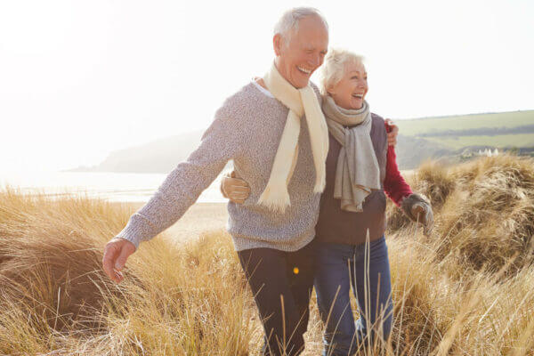 Happy senior couple at the beach in winter.