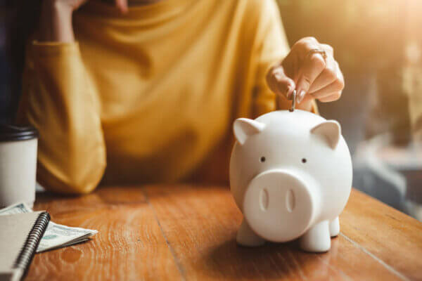 Woman putting money in a piggy bank