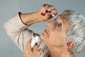 Woman putting eye drops in