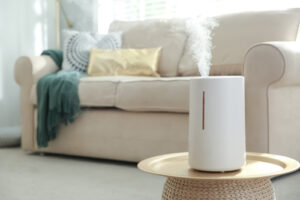 humidifier on a side table in living room with a tan couch in the background