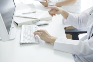 Hands on keyboard pointing at monitor